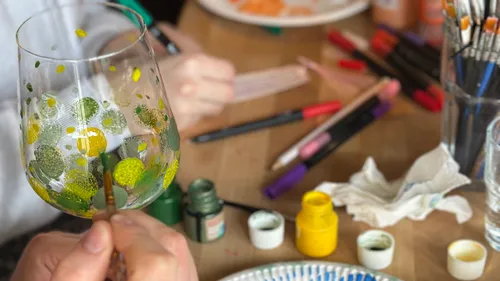 Person bemalt Glas im Kunstkurs.