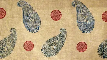 Paisley and circle pattern on fabric background.