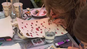 Person painting on fabric with paintbrush.