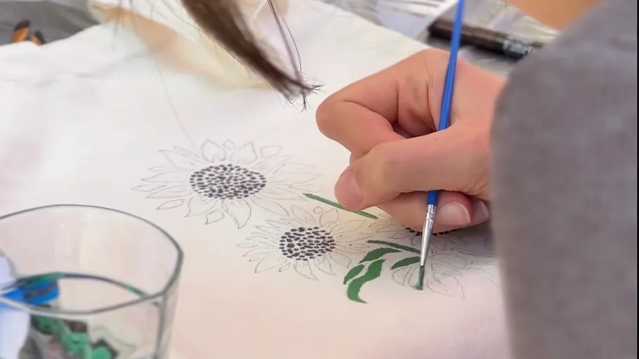 Hand painting sunflowers on light fabric.