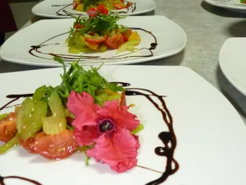 Colorful salad decorated with a flower on a plate.