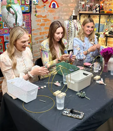 Drei Frauen basteln am Tisch mit Dekorationen.