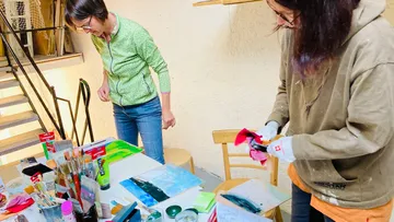 Two people painting in an art studio.