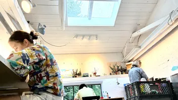 Drei Personen arbeiten im Kunststudio.