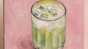 Gemaltes Glas mit Eisgetränk auf rosa Hintergrund