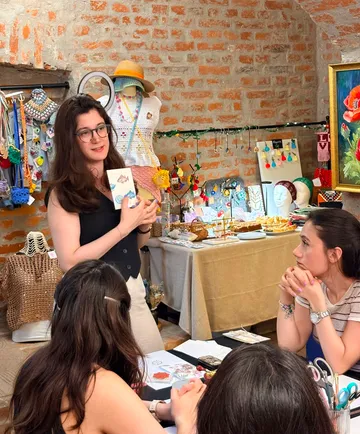 Woman presenting in a craft workshop setting.