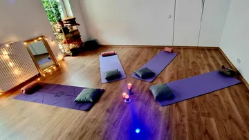 Yogamatten mit Kissen und Kerzen im Studio.