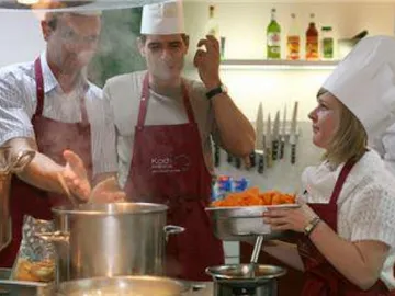 Three chefs prepare meals in a kitchen.