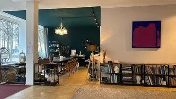 Kunststudio mit Bücherregalen und Gemälde.