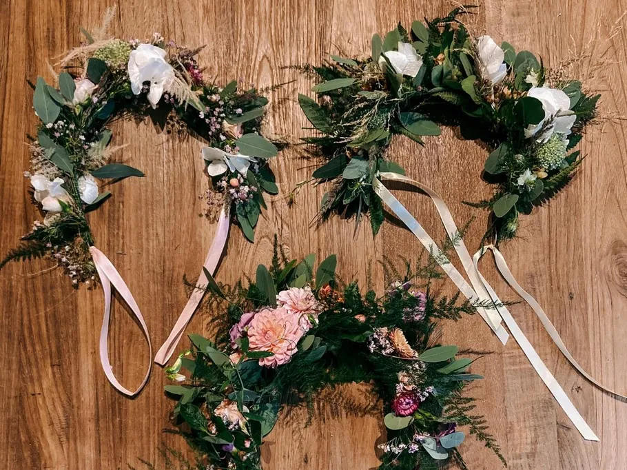 Wreaths of flowers lie on a wooden background.