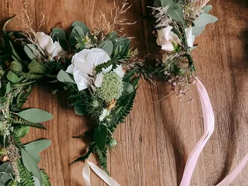Flower wreaths are decorated on a wooden table.