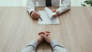 Zwei Personen sitzen am Holztisch.