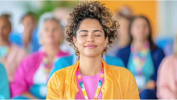 Person meditates, eyes closed, colorful event.