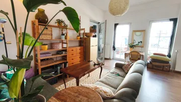 Gemütliches Wohnzimmer mit Pflanzen und Möbeln.