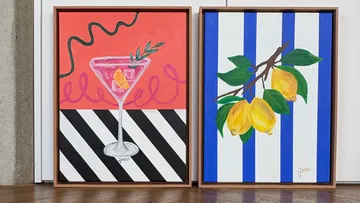Two framed paintings on wooden floor.