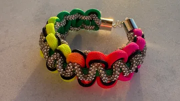 Buntes Armband mit Strasssteinen auf Tisch.