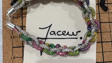 Buntes Perlenarmband auf Korkbrett.