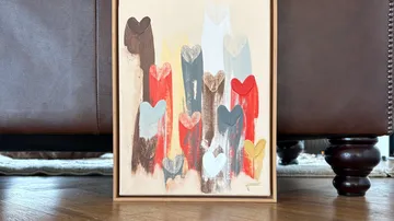 Colorful heart painting on wooden floor.