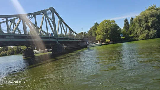 Bridge over river with sunny sky.