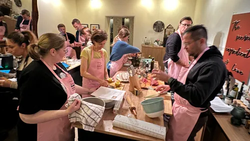 Gruppenkochkurs mit rosa Schürzen.