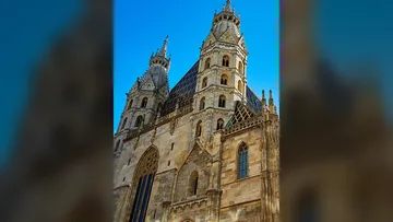 Gothic cathedral towers against blue sky.