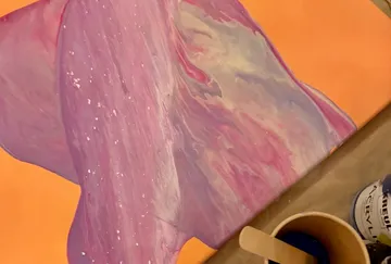 Canvas with swirling pink and purple paint.