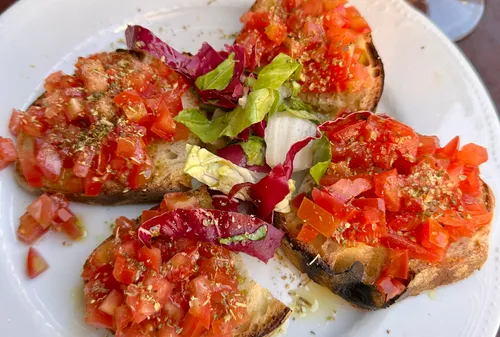 Bruschetta mit Tomaten und Kräutern auf Teller.