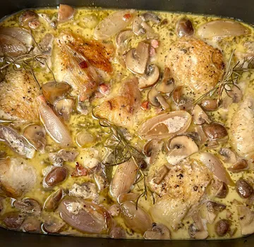 Chicken thighs cooking with mushrooms and herbs.