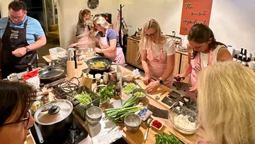 People cooking in a kitchen together.