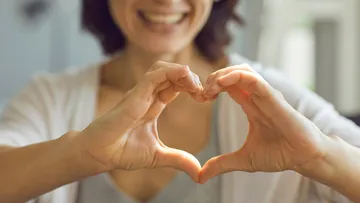 Hands forming heart, person smiling
