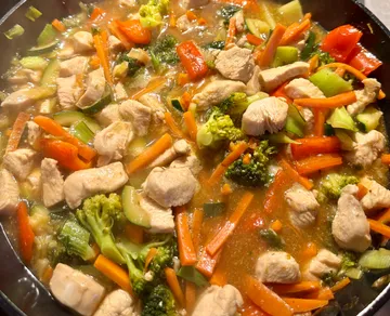 Stir fry with chicken and vegetables cooking.