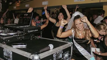 Bride dancing at lively party scene.