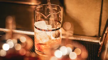 Glas mit Eis wird mit Flüssigkeit gefüllt.