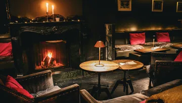 Gemütliche Lounge, Kaminwärme, stimmungsvolle Beleuchtung.
