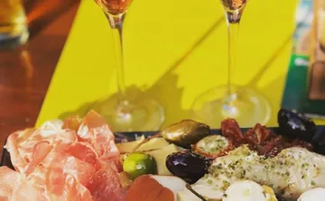 Antipasto-Platte mit zwei Weingläsern.