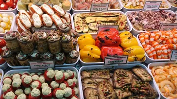 Assorted antipasti displayed in a market counter.