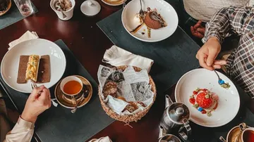 People eating desserts at a table.