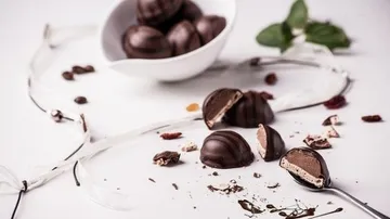 Pralinen auf weißem Untergrund mit Löffel.