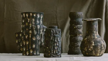 Four textured ceramic vases, on display table.