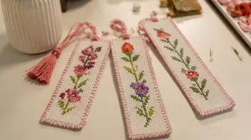 Three embroidered bookmarks on a table.