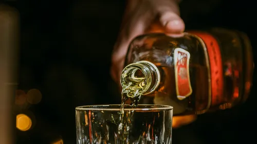 Whiskey bottle pouring into a glass.