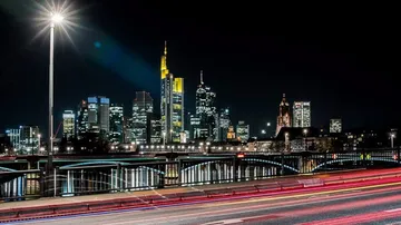 Beleuchtete Wolkenkratzer bei Nacht, von Brücke aus.