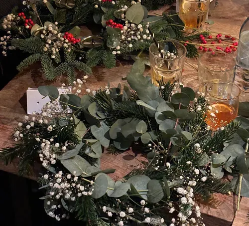 Wreaths on a wooden table with drinks.