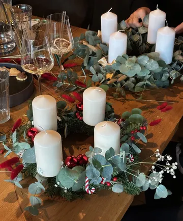 Christmas wreaths with candles on table.