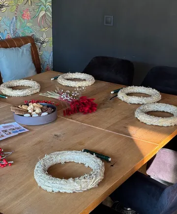 Straw wreaths and decorations on a wooden table.
