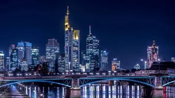 Wolkenkratzer bei Nacht am Fluss beleuchtet.