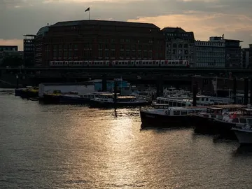 Boote liegen im Wasser, während ein Zug darüber fährt.