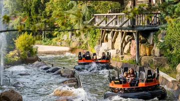 People enjoying river rapids ride at park.
