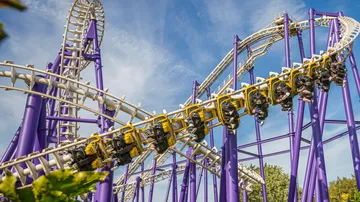 Roller coaster twisting in amusement park.