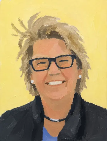 Smiling woman in glasses on yellow background.